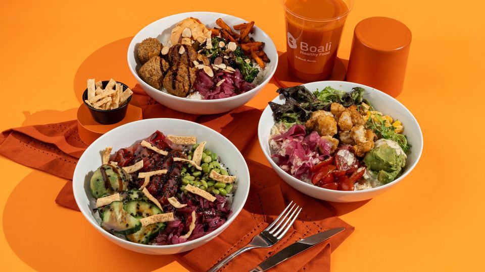 Three Boali bowls with a fresh juice on an orange table