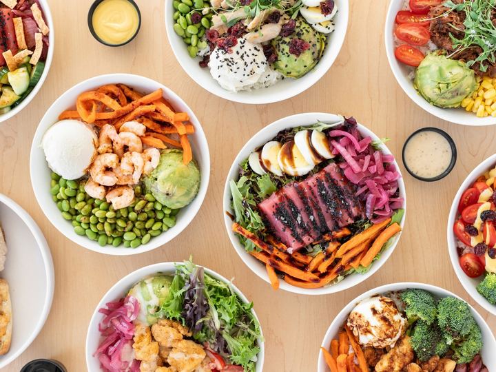 Bowls and salads with fresh toppings, seen from above
