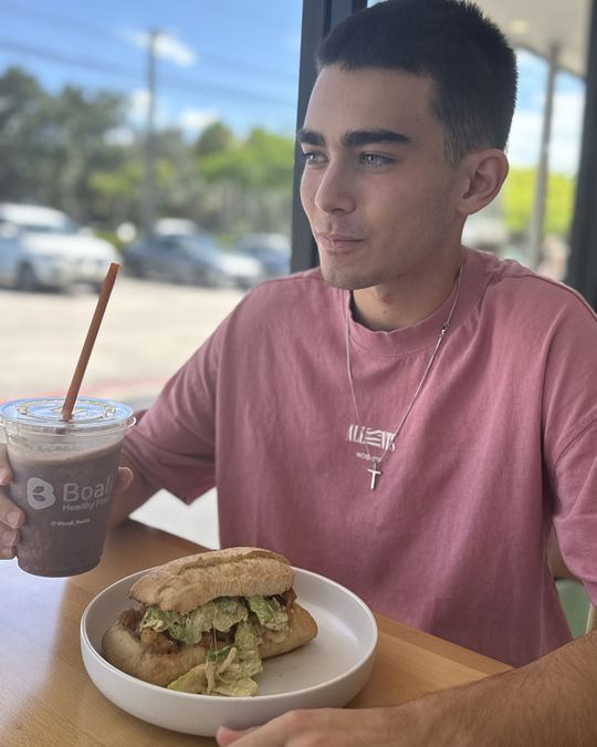 Guest with a Boali shake and sandwich at the Plantation restaurant